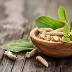 Korzeń ashwagandhy w drewnianej miseczce, z liśćmi. Naturalne wsparcie dla osób z hashimoto.