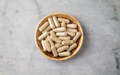 Kapsułki z ashwagandhą w miseczce. Zanim zaczniesz stosowanie, sprawdź potencjalne ashwagandha skutki uboczne.