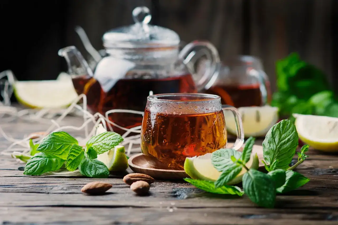 Aromatyczny napar z rooibos, parujący w szklance, z miętą i cytryną. Co to rooibos? To nap&oacute;j o bursztynowym kolorze, idealny na chłodne wieczory.
